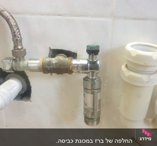 צינור מתכת עם שסתום וברז מתכת על קיר קרמיקה